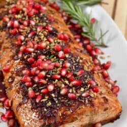 closeup if garnished holiday baked salmon in serving dish.