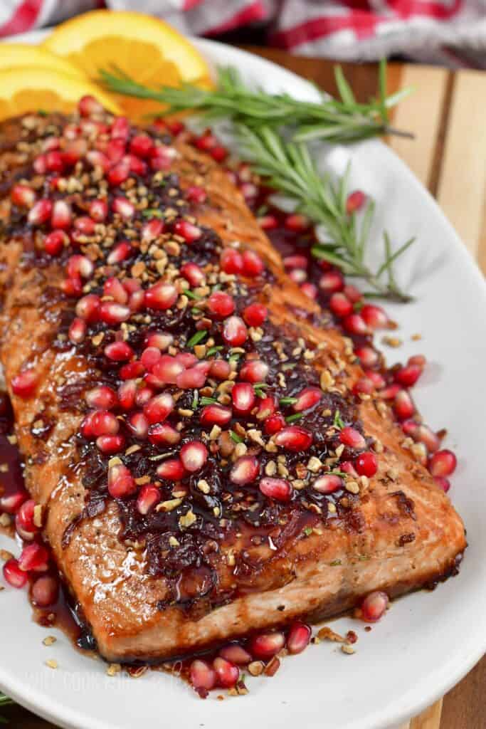 closeup if garnished holiday baked salmon in serving dish.