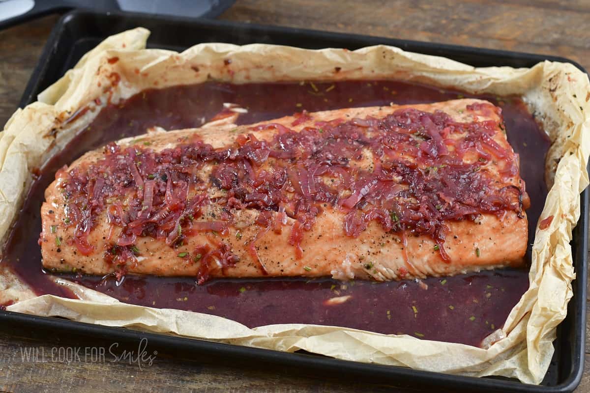 flipped whole salmon filet in the sauce in the baking dish.
