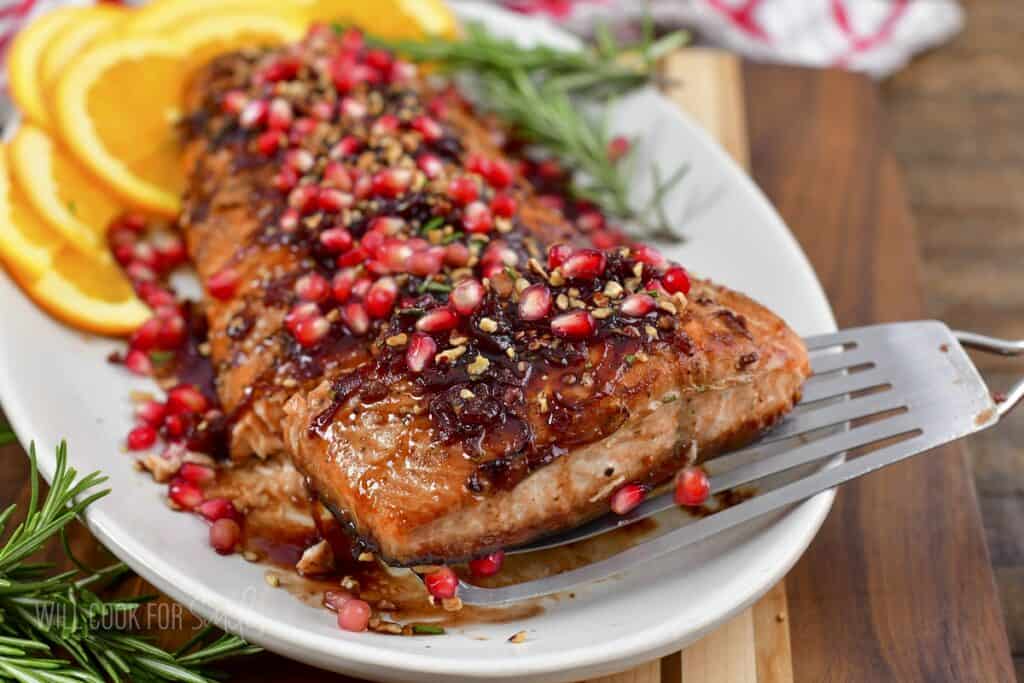 taking out one slice of the salmon from the serving dish.