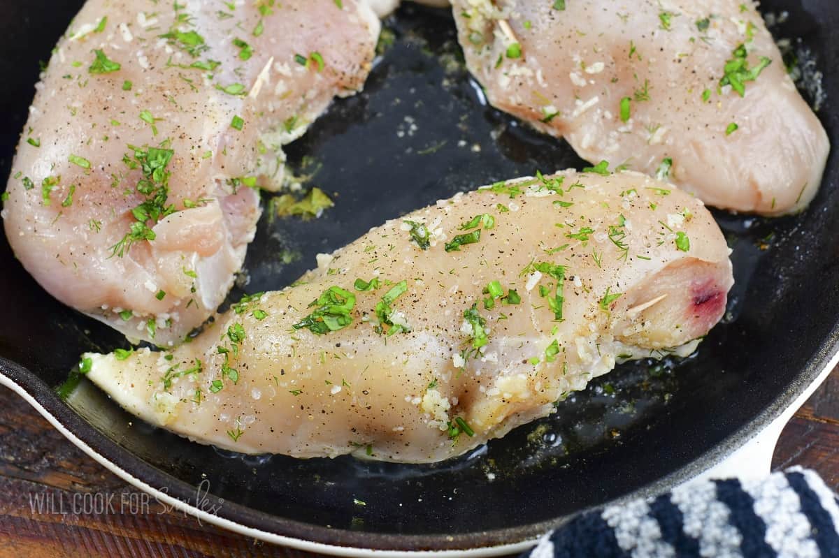 uncooked stuffed chicken breasts in the pan.
