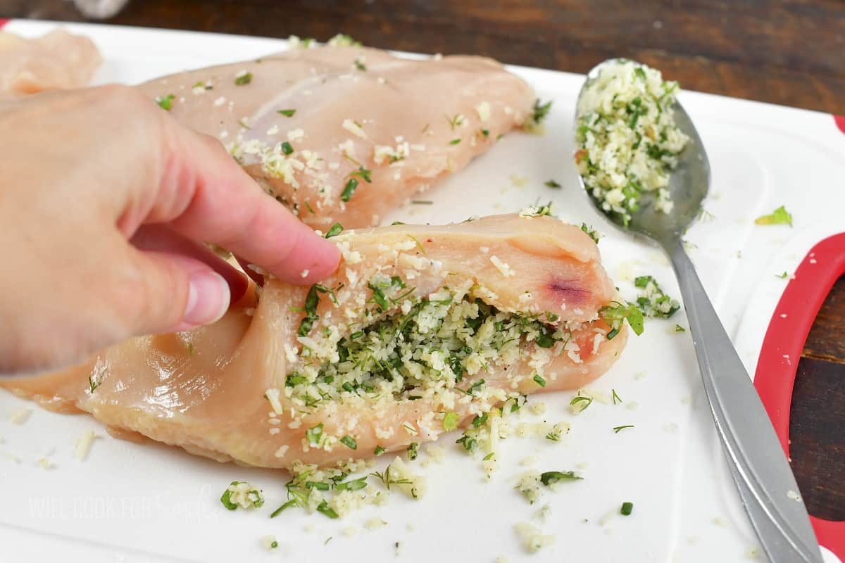 stuffing chicken breast with parmesan herb filling.