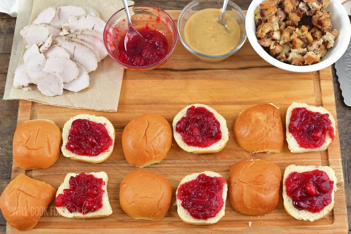 adding cranberry sauce to bottom slider buns.