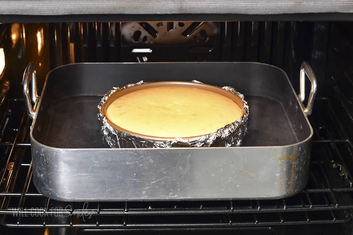 cheesecake sitting in the water bath, in the oven.