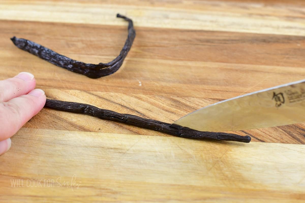 slicing the vanilla bean with a knife, lengthwise.