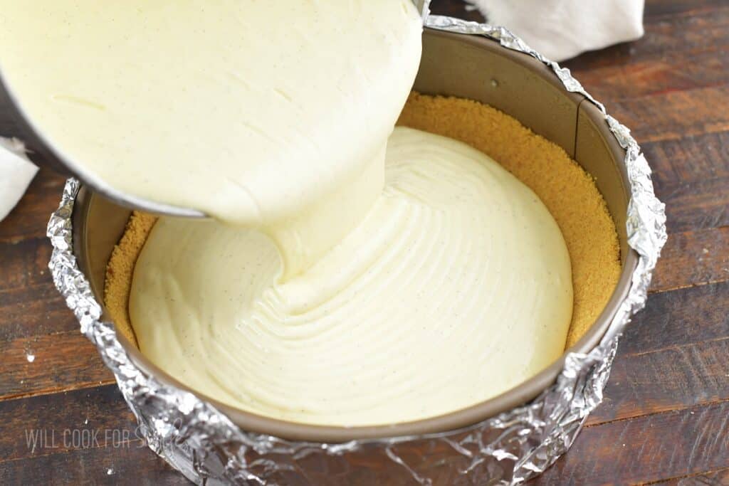 pouring in cheesecake batter into the springform.