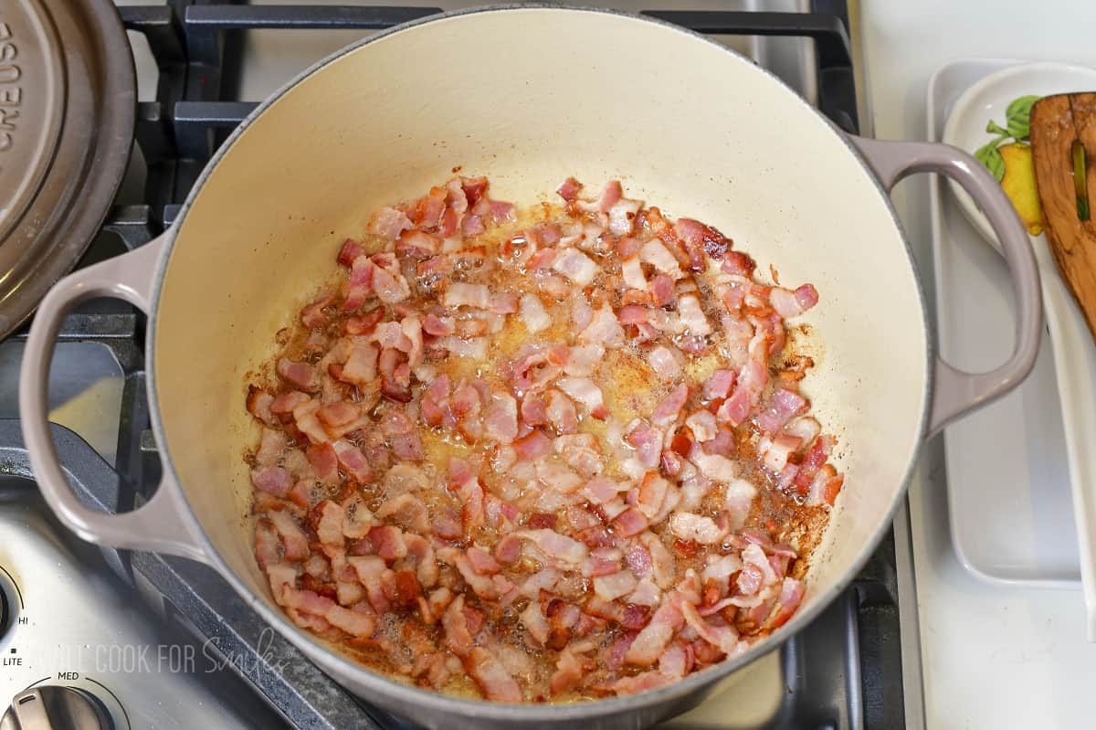 searing diced bacon in a Dutch oven.