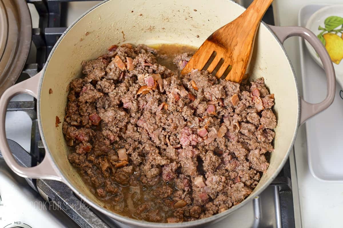 cooking ground beef and bacon together.