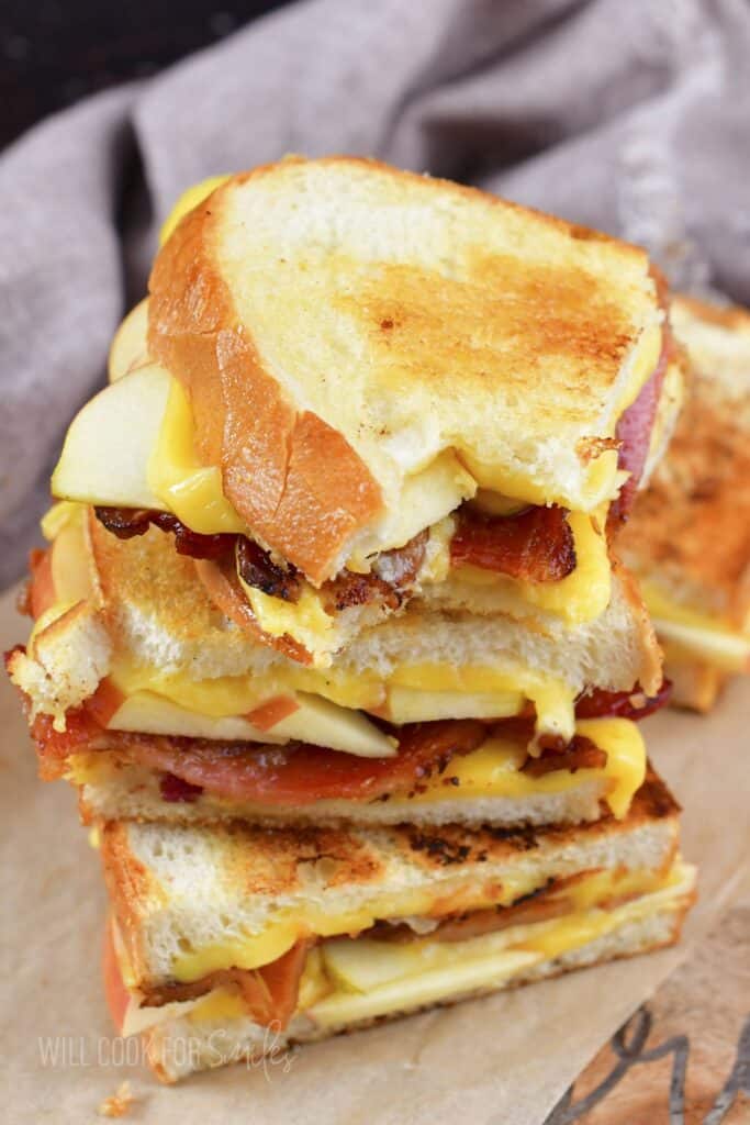 three stacked grilled cheese halves with one piece bitten.