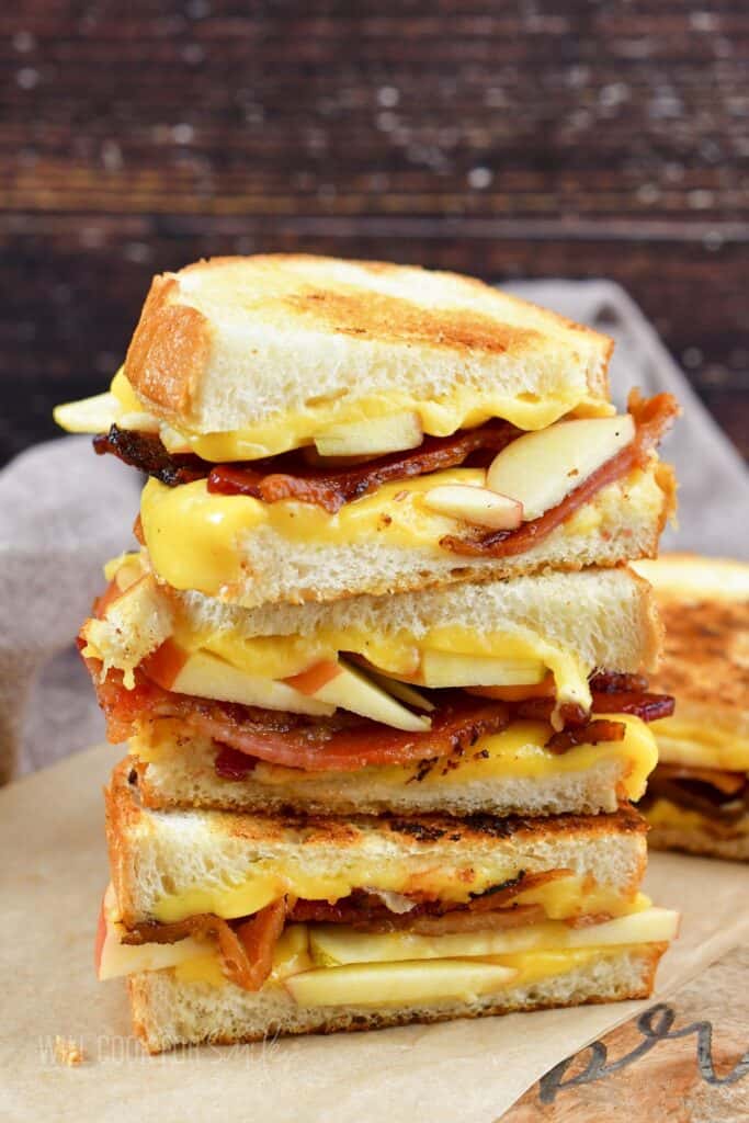 side view of three apple bacon grilled cheese halves stacked.