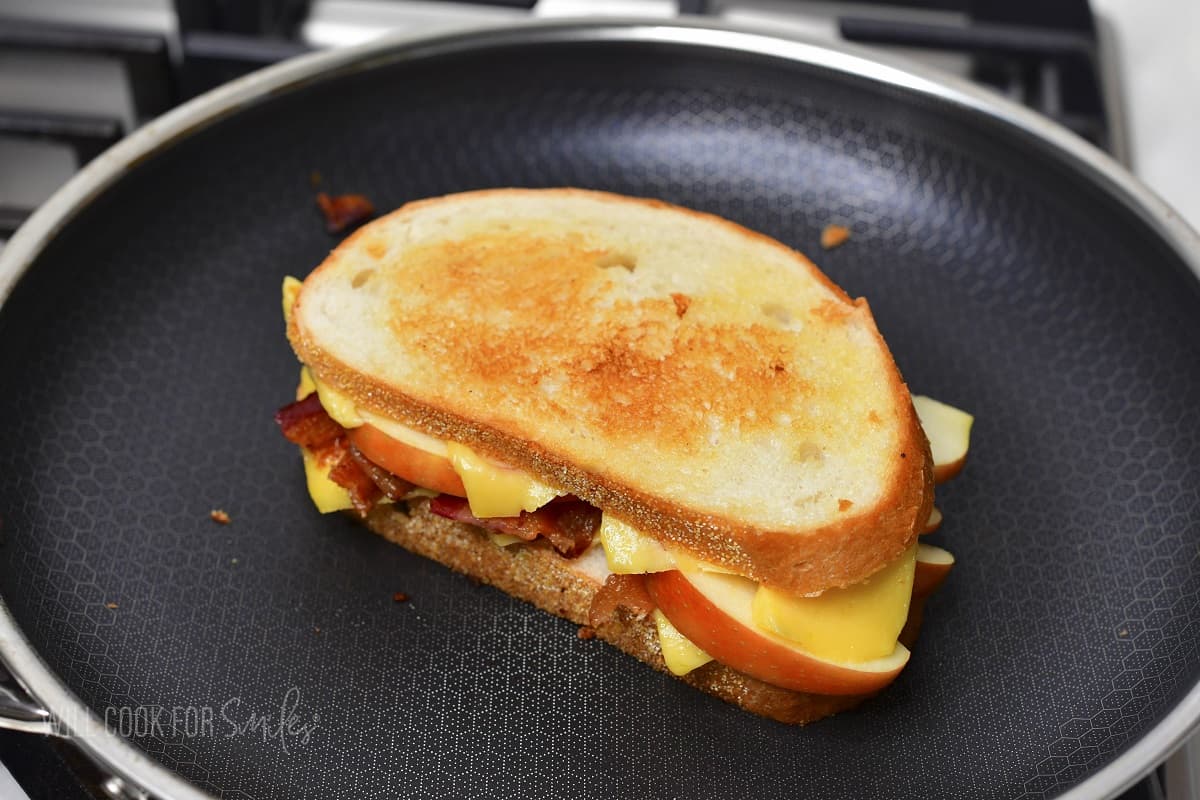 grilled cheese with bacon and apple cooking in the pan.