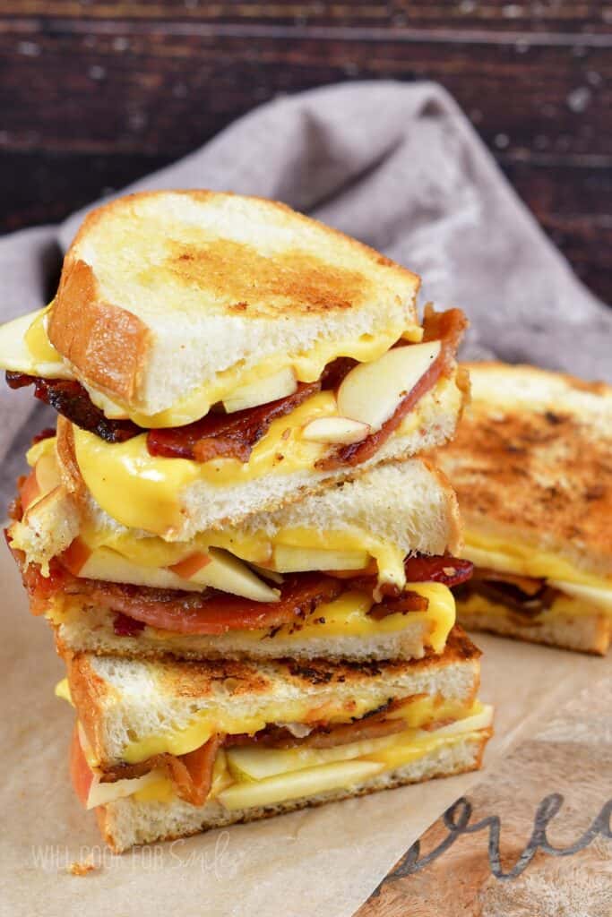 three bacon apple grilled cheese halves stacked.