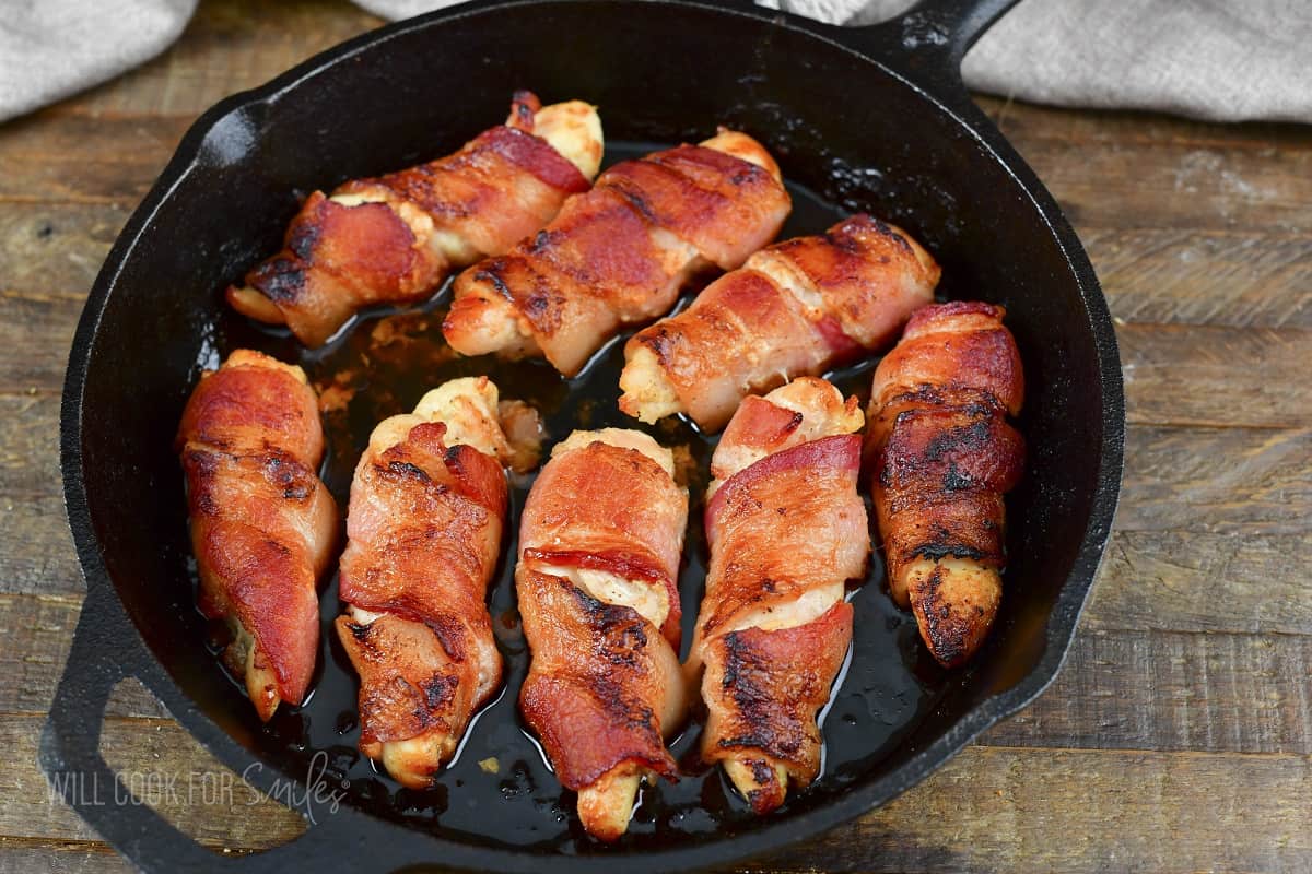 bacon wrapped chicken tenders in the skillet after baking.