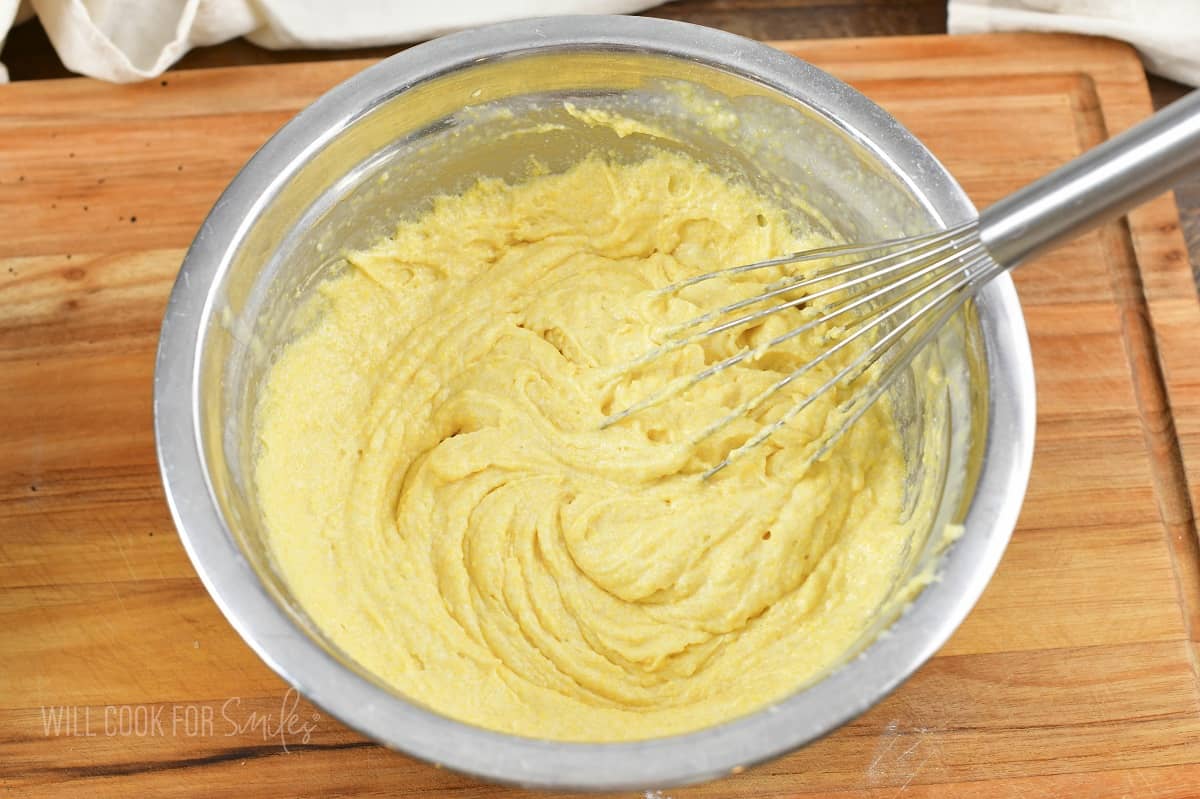 mixing ingredients for cornbread in a bowl.