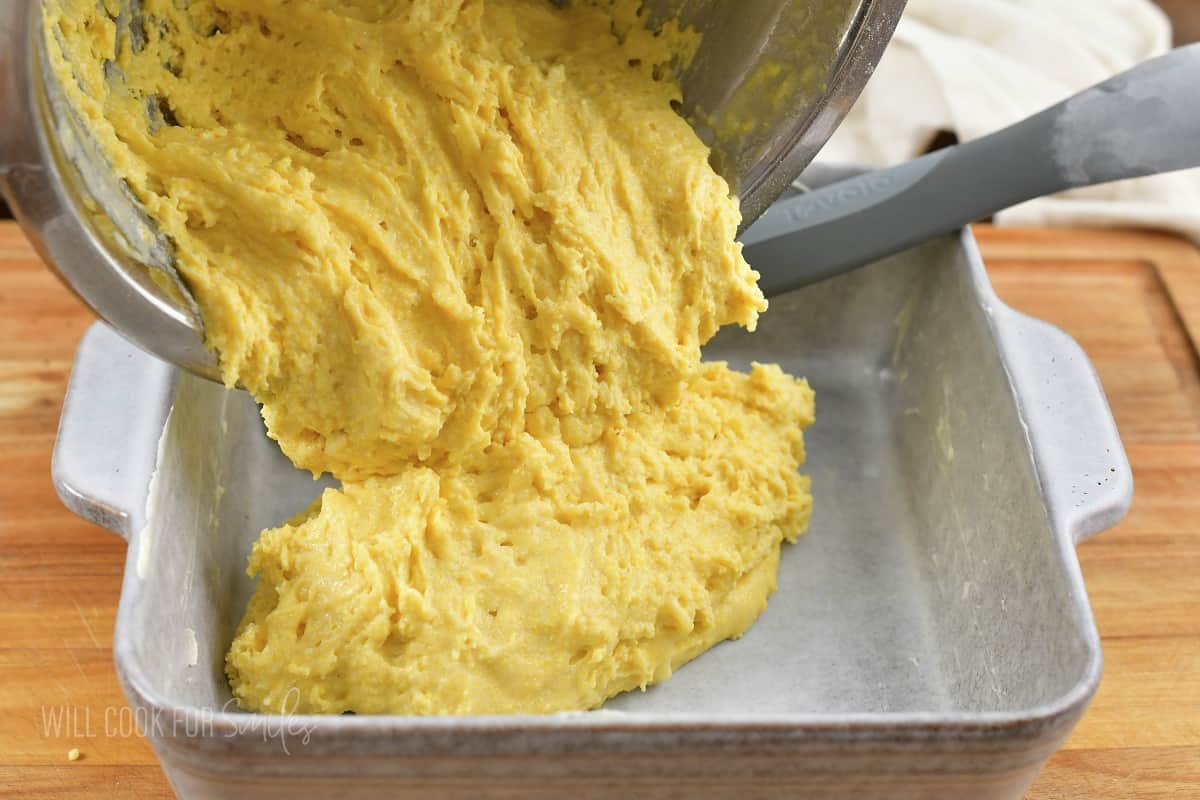 adding cornbread batter into the baking dish.