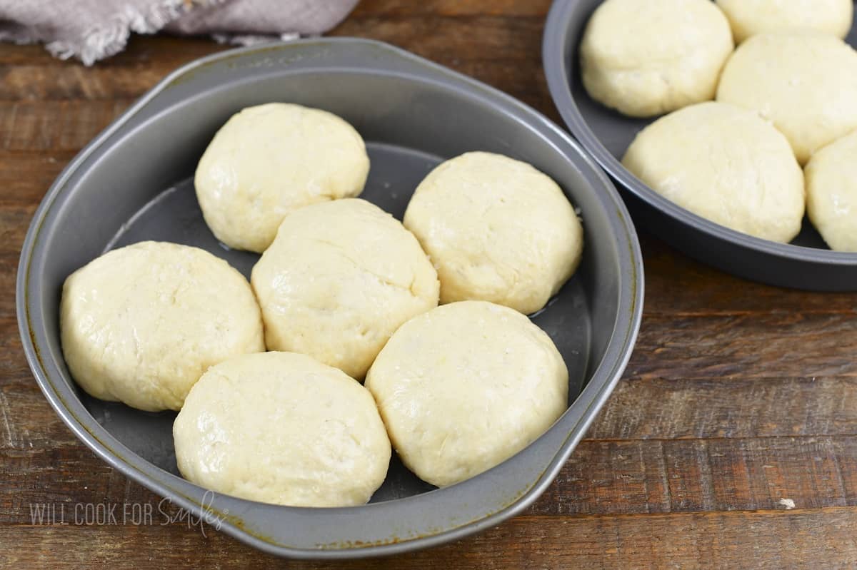 raised dinner rolls in a baking dish brushed and salted.