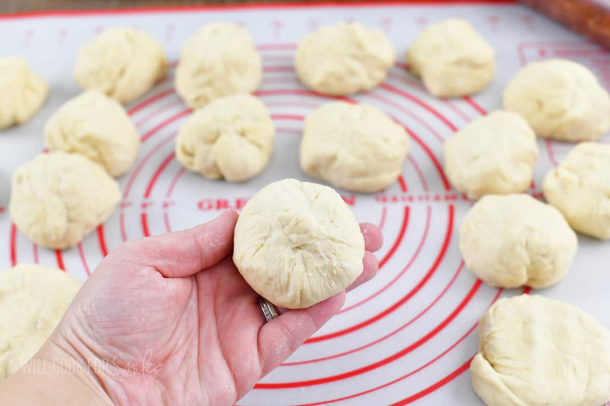 holding a rolled dough with others around.