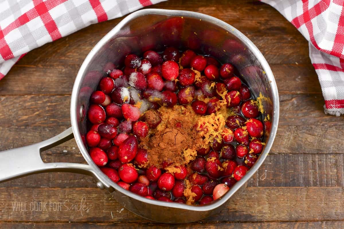ingredients for cranberry sauce combined in a pot.