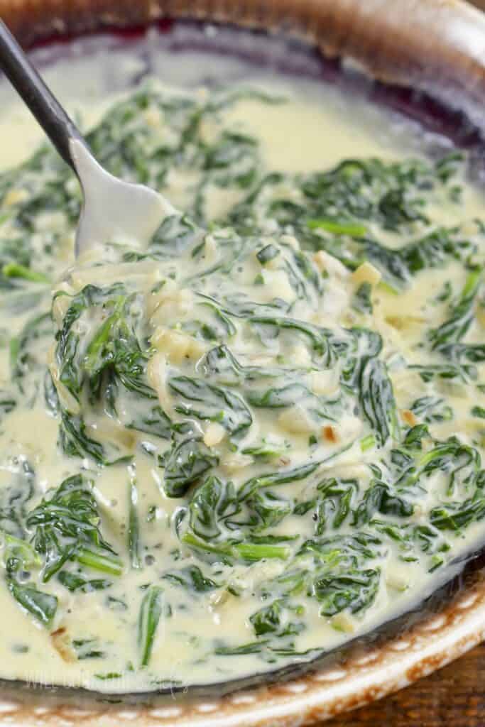 closeup of spooning out some creamy spinach.