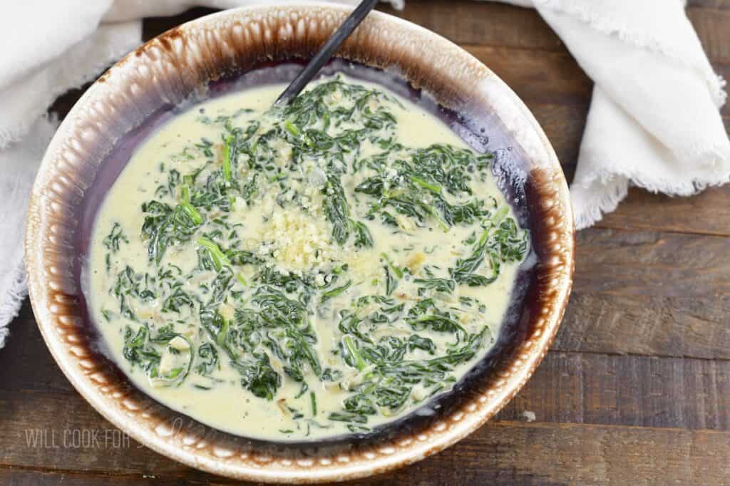 creamed spinach topped with parmesan cheese in a bowl.