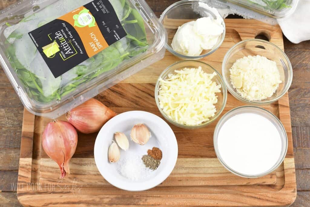 ingredients to make creamed spinach on cutting board.