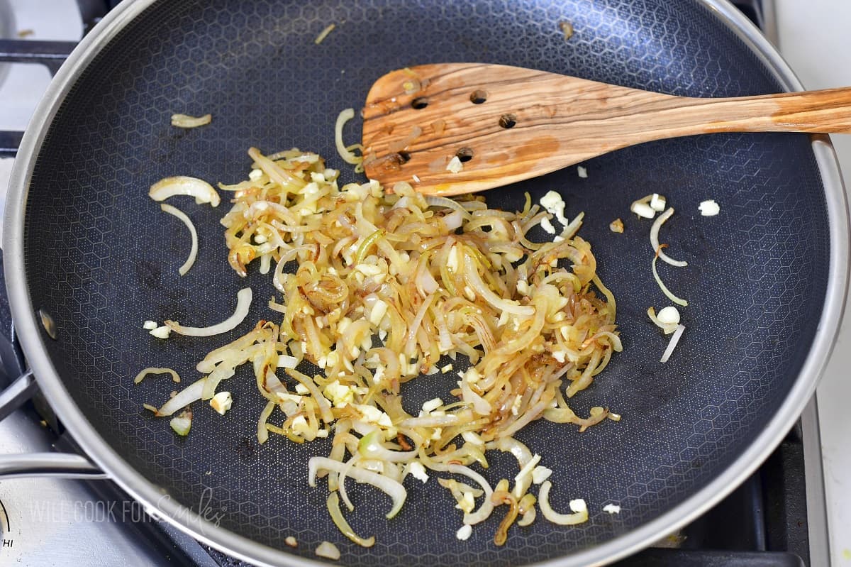 sautéed onions and garlic in a pan with a spatula.