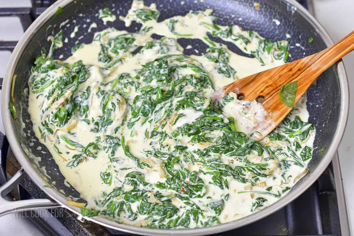 stirring the spinach, cheese, and cream together in a pan.