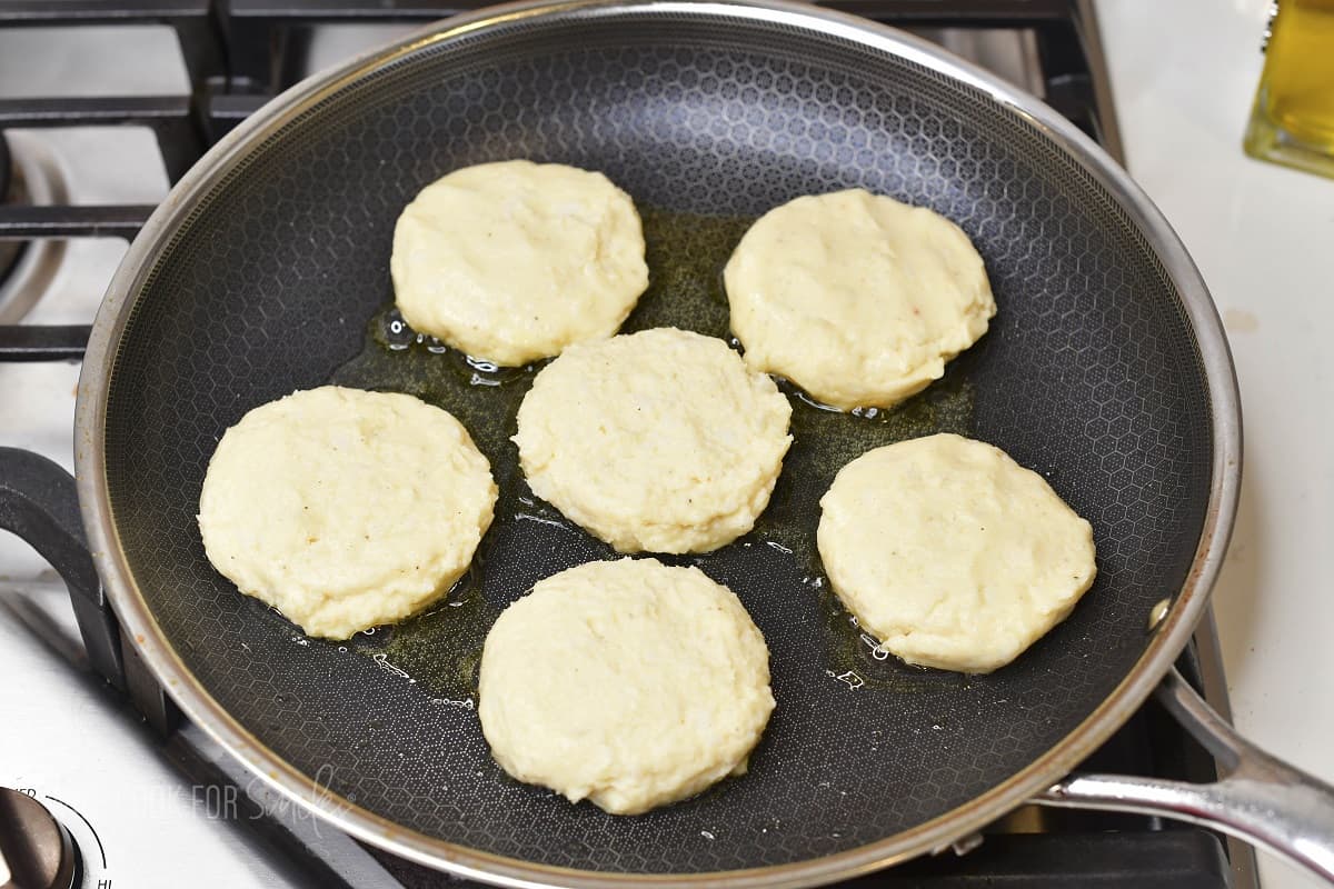 cooking six potato cakes in the cooking pan.