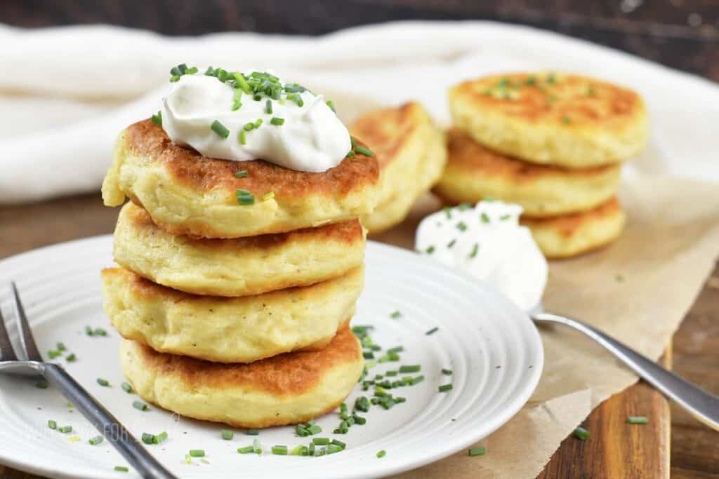 closeup stacked mashed potato cakes with more around.