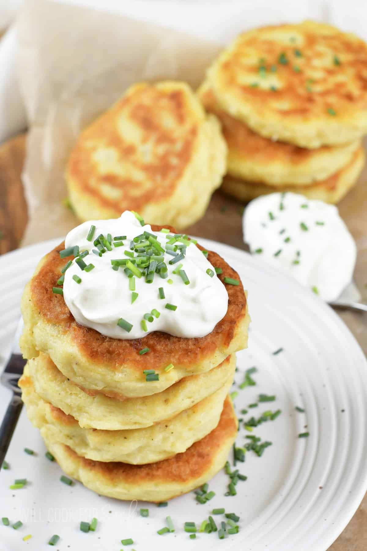 stacked mashed potato cakes and some next to the plate.