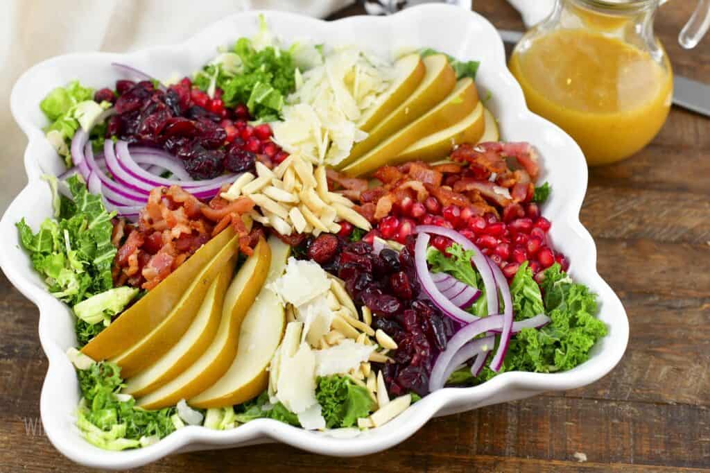closeup of thanksgiving salad and dressing next to it.