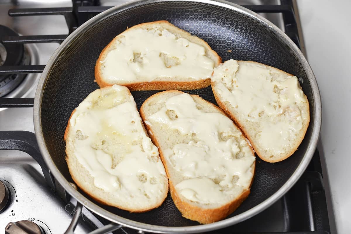 four slices of bread with brie in the cooking pan.