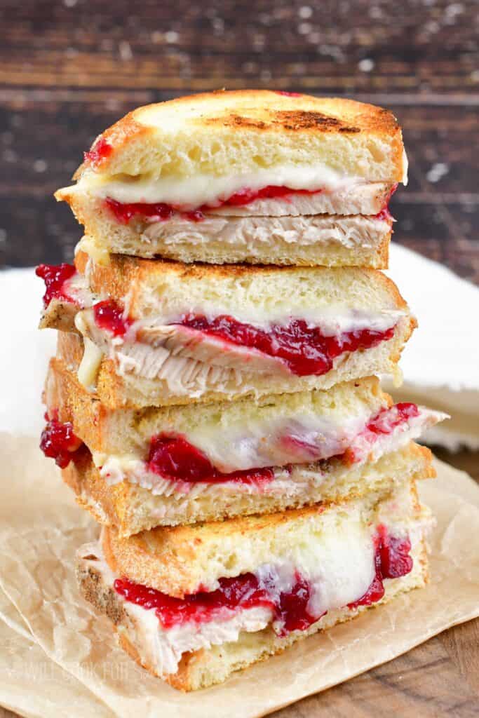 four turkey cranberry grilled cheese halves stacked.
