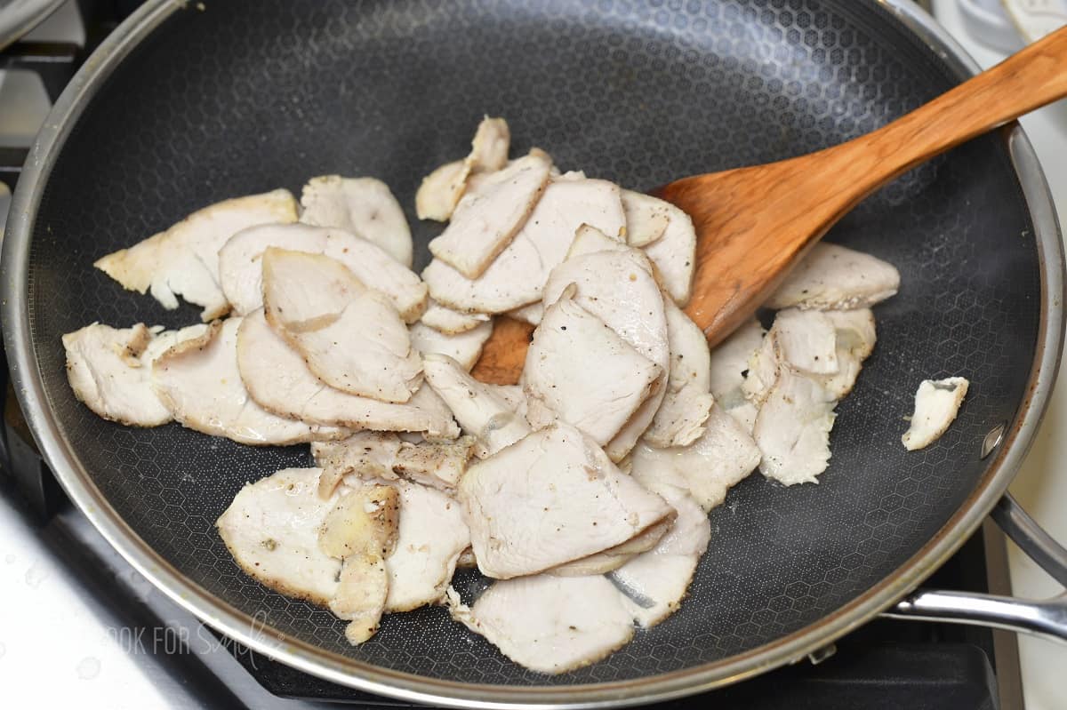 sautéing sliced turkey breast in the pan.