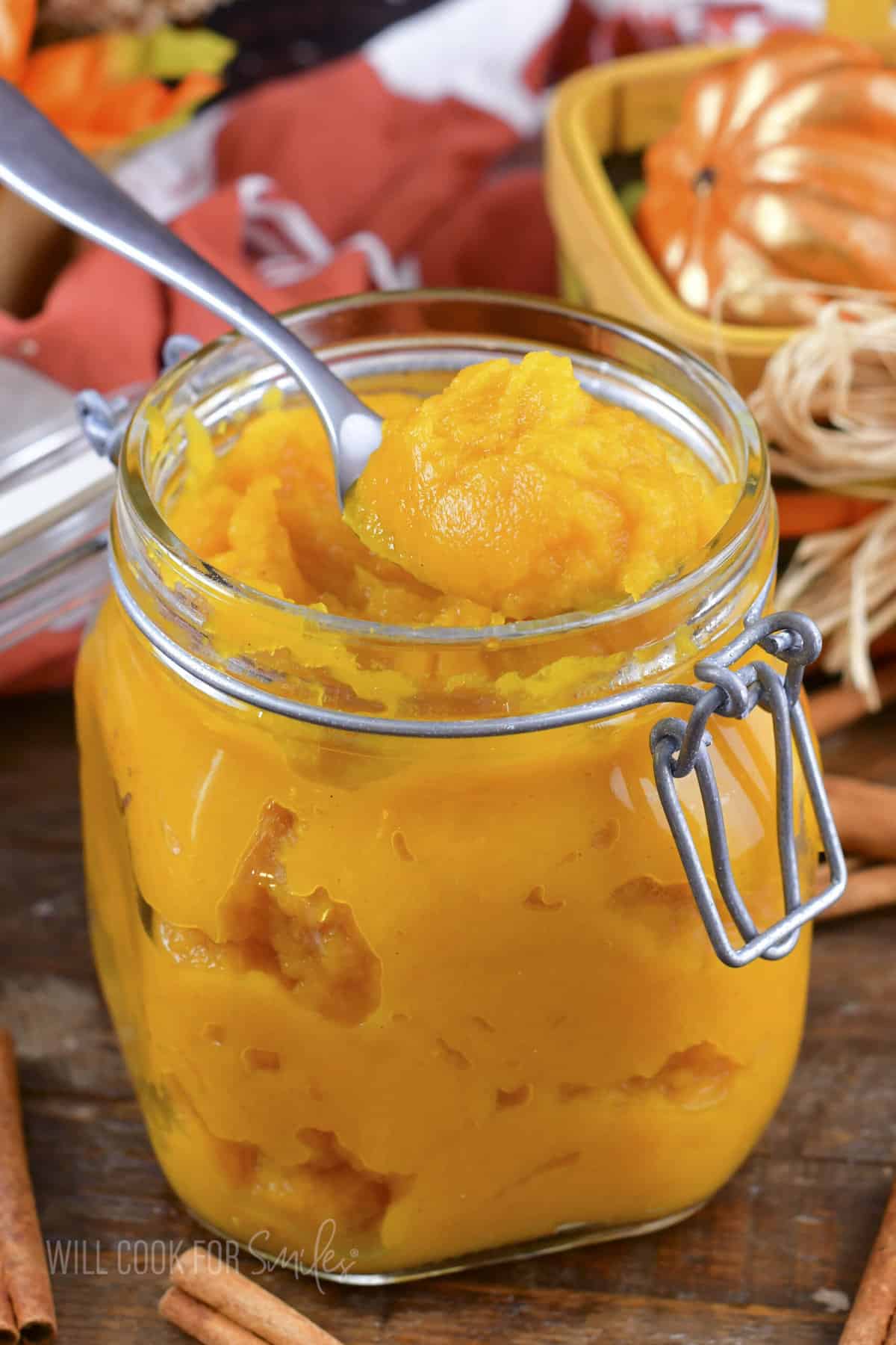 scooping out pumpkin puree from the jar with a spoon.