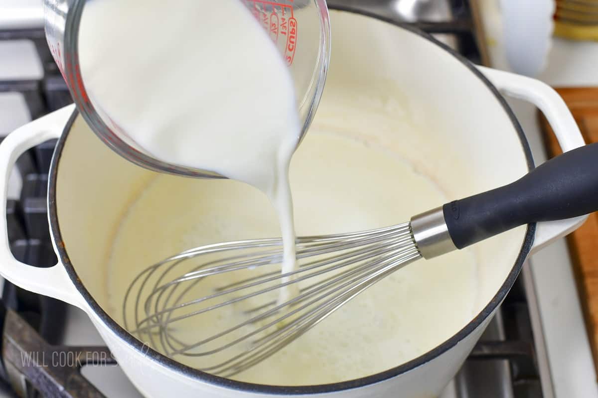 adding milk to the white pot to make cheese sauce.