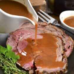 pouring au jus over the prime rib.