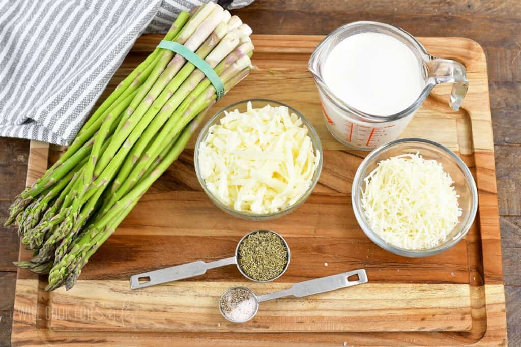 ingredients for creamy baked asparagus on a board.