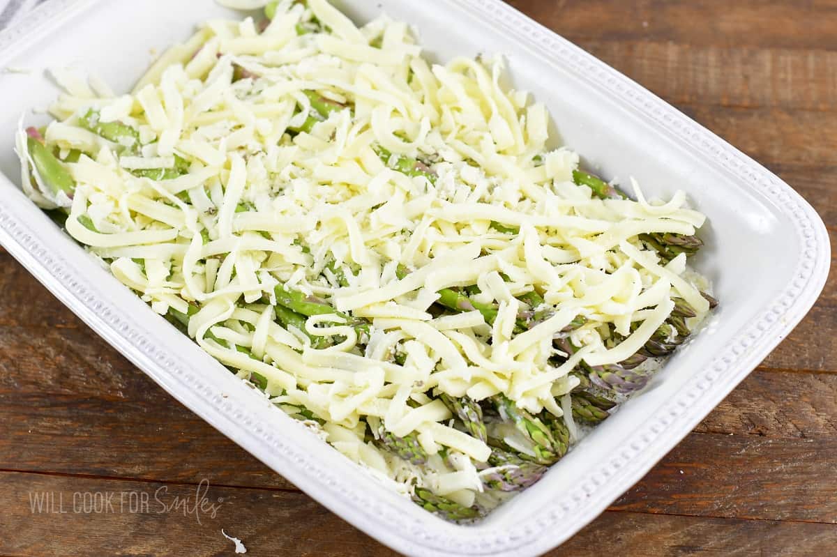 asparagus in a baking dish with cream and cheese.