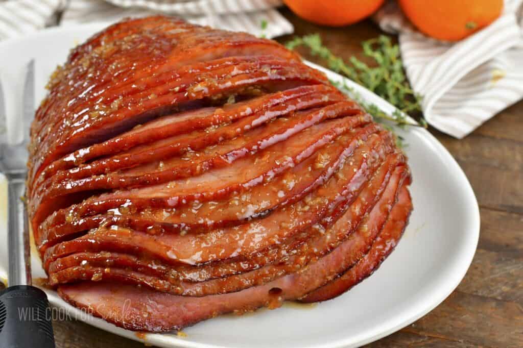 baked glazed ham on white platter.