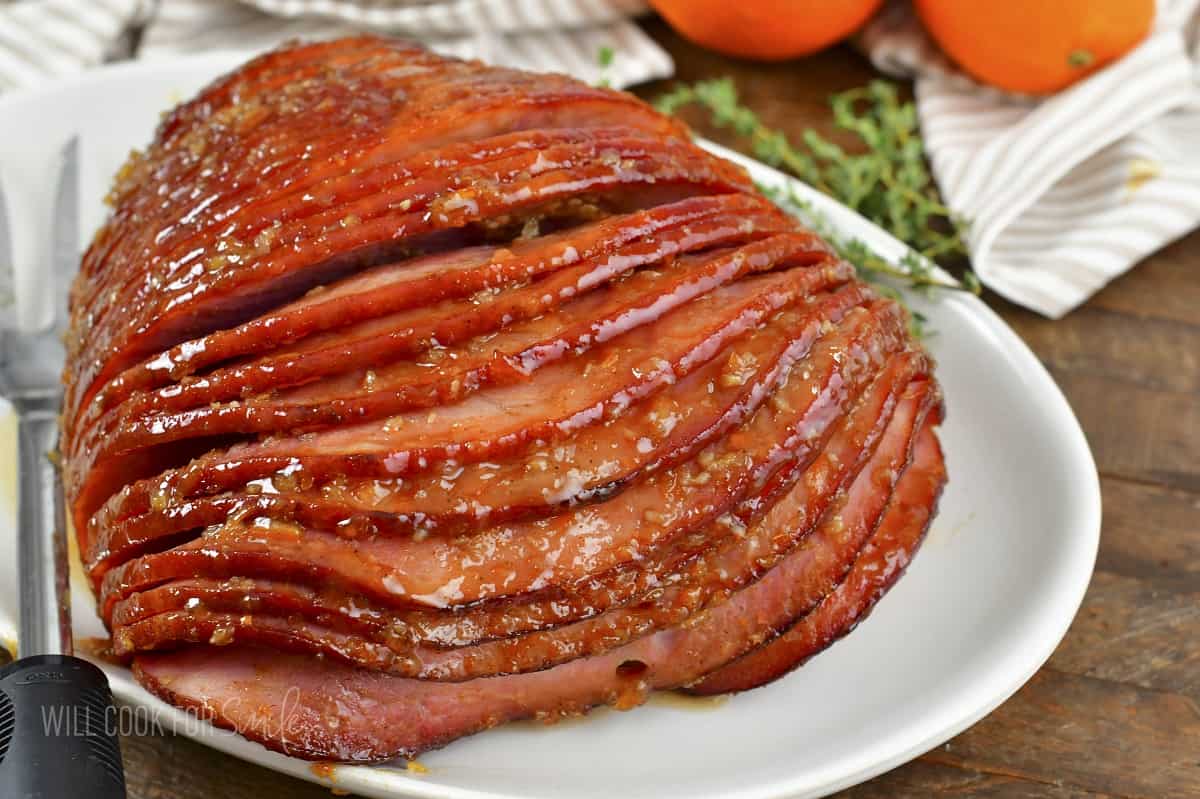 baked glazed ham on white platter.