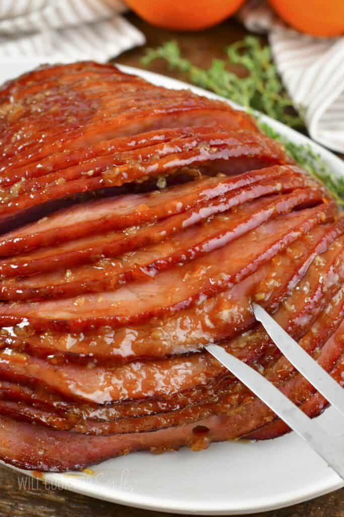 pulling apart baked ham with a fork.