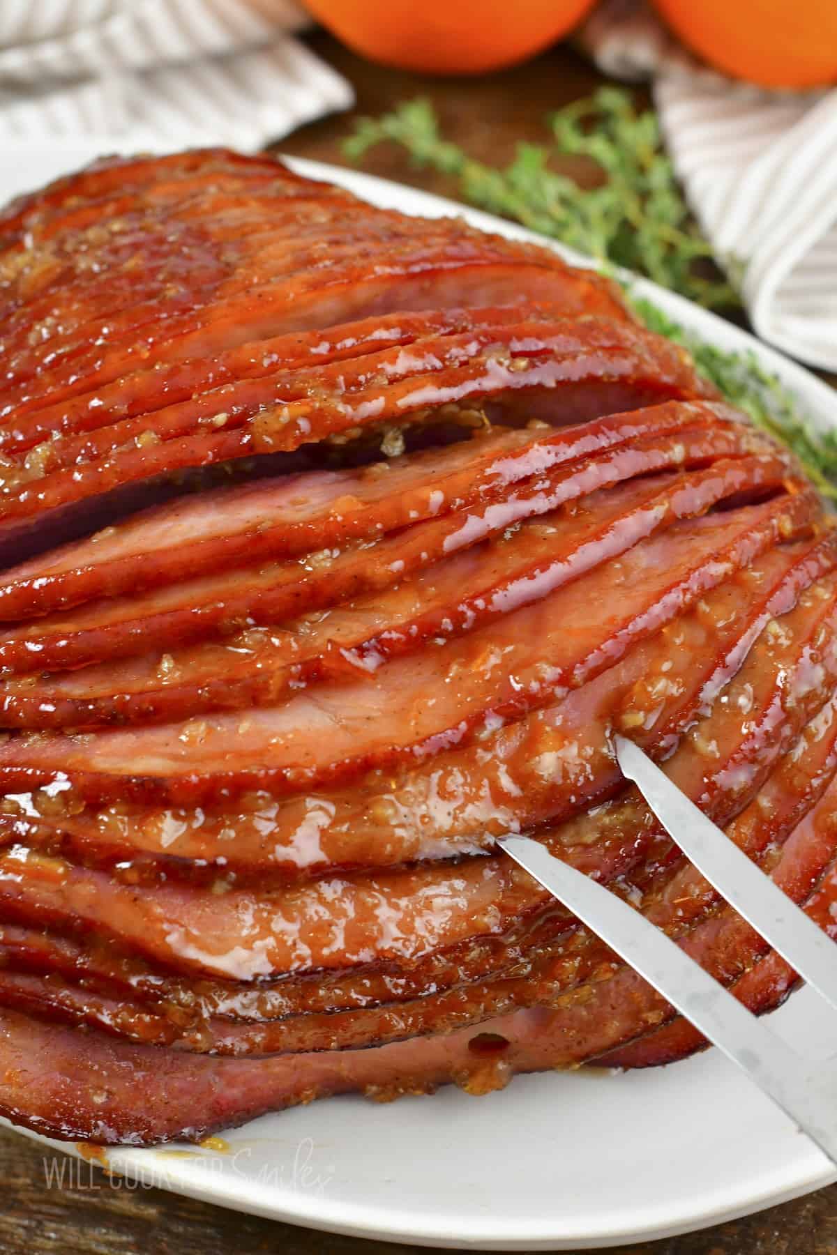 pulling apart baked ham with a fork.