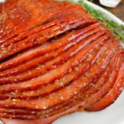 squared closeup of baked ham with orange ham glaze.