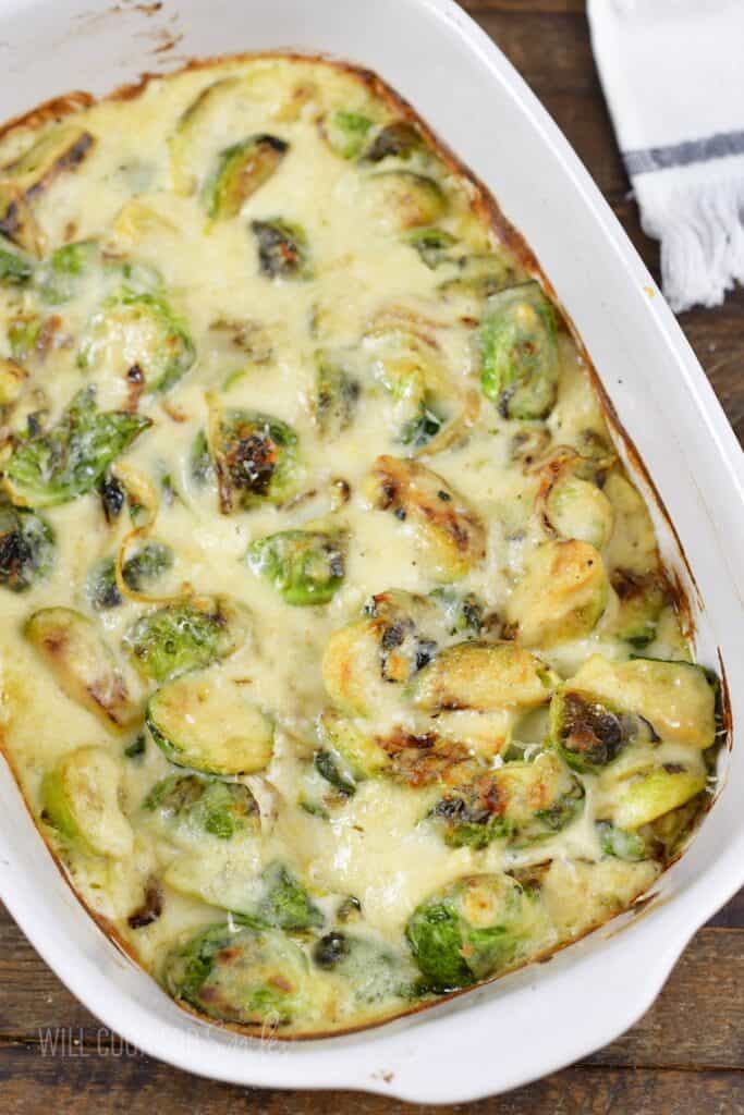 top view of creamy baked brussels sprouts in a baking dish.