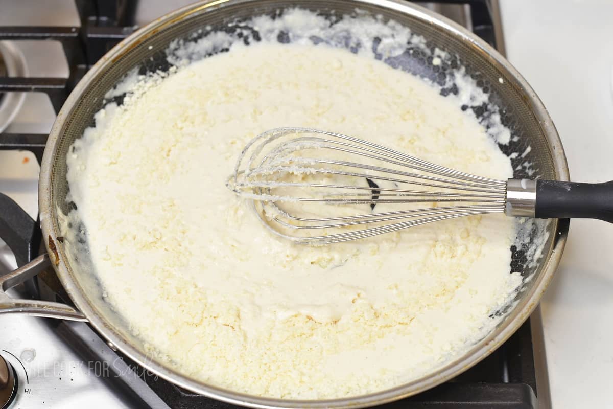 adding grated parmesan cheese to the cream sauce.