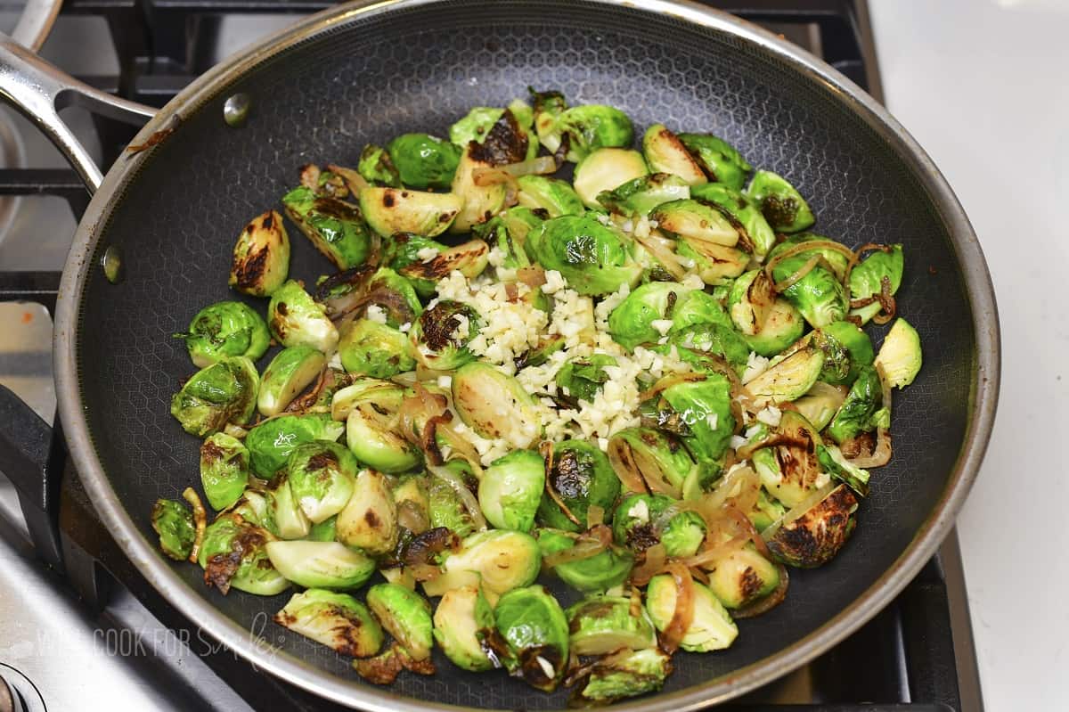 seared brussels sprouts with garlic in a pan.