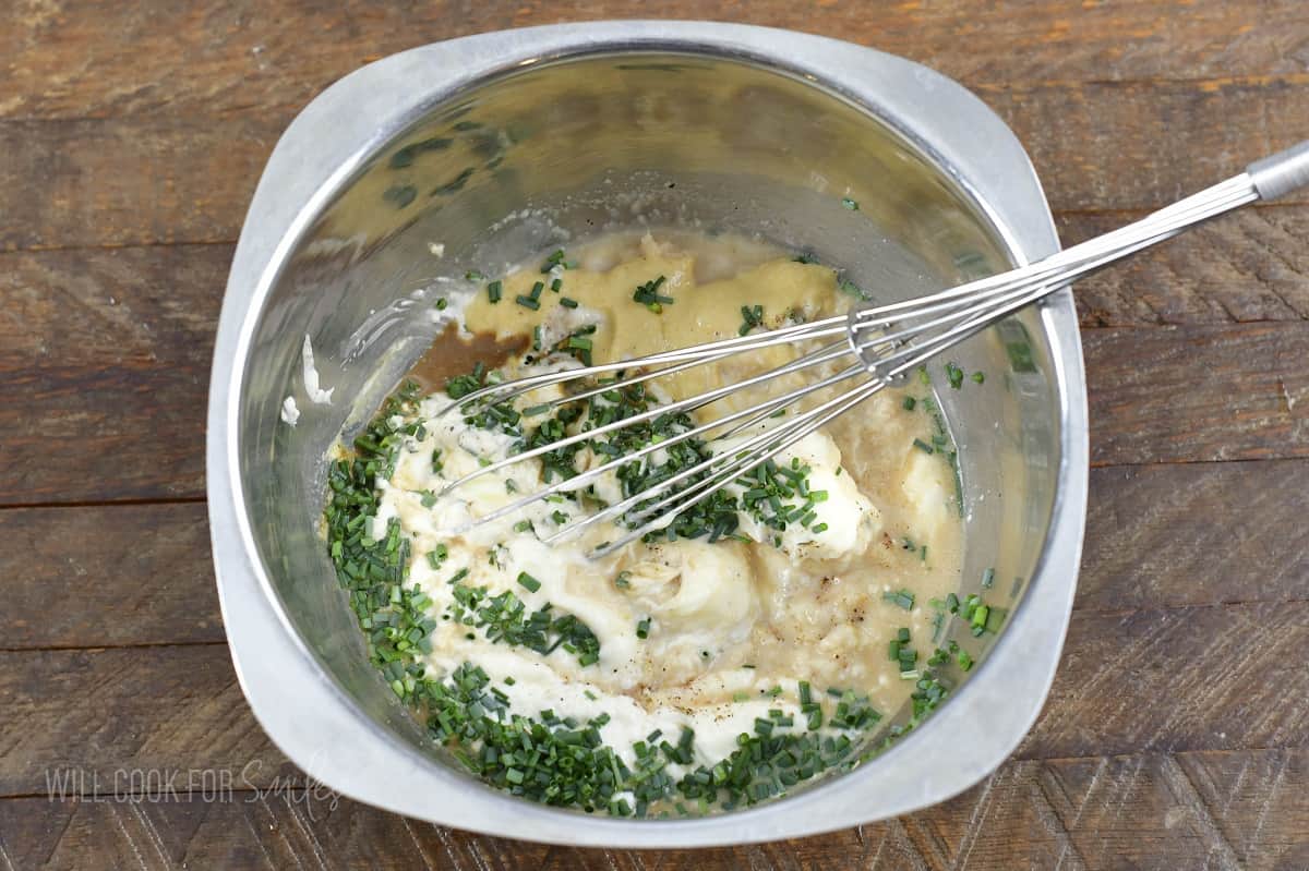 whisking ingredients for horseradish sauce in a bowl.