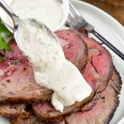 spreading some horseradish sauce over the prime rib.