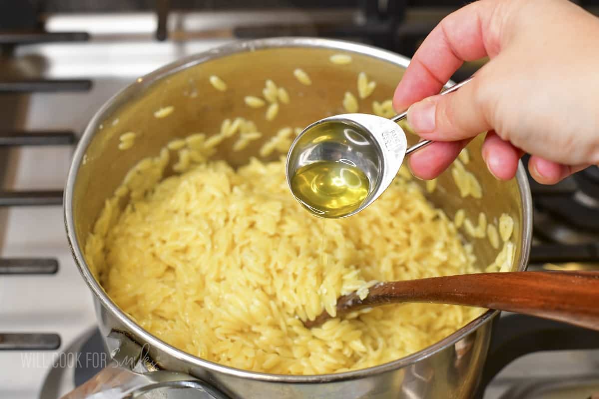 adding some truffle oil to the orzo with cheese.